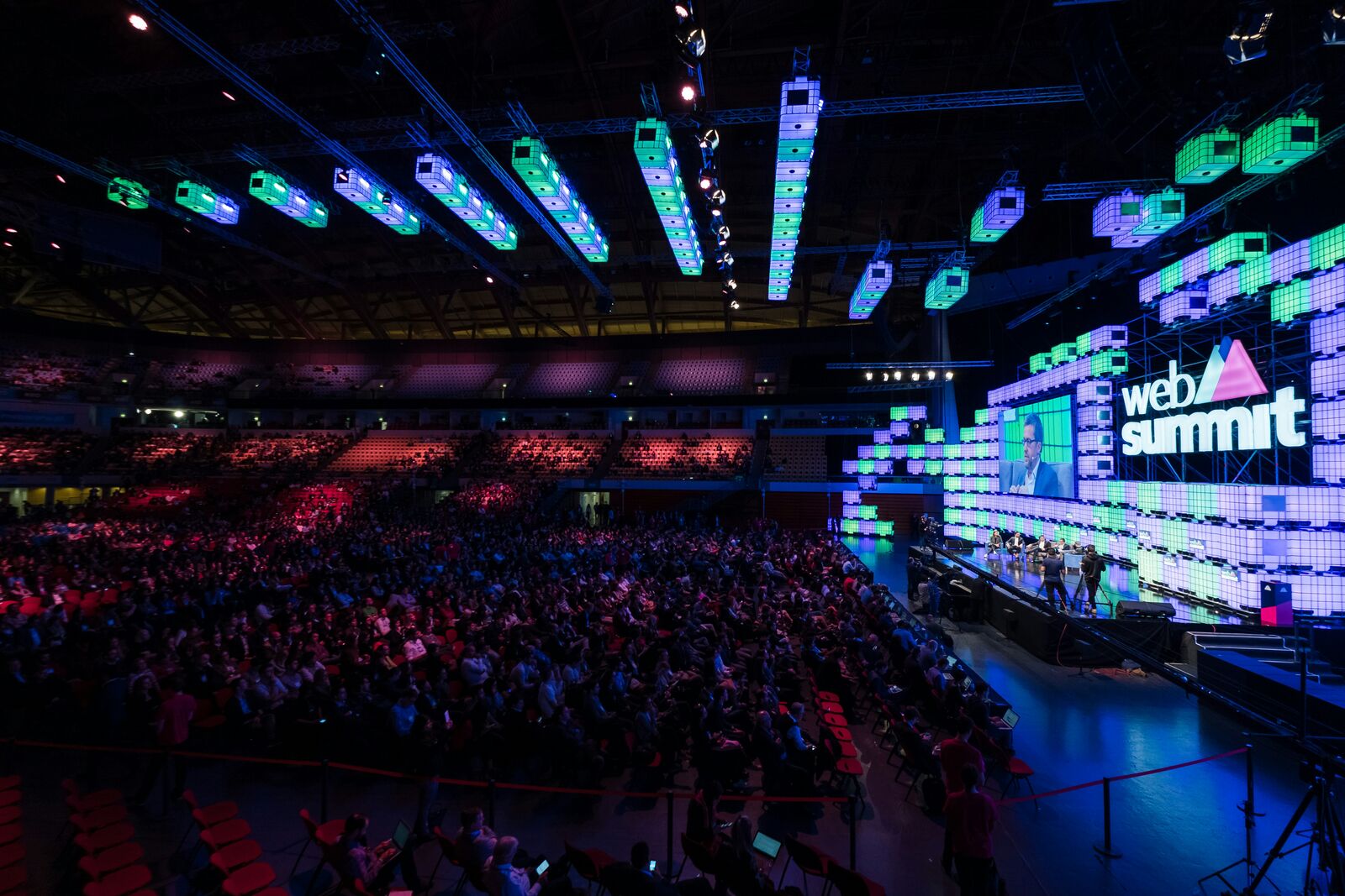 A packed audience watching a panel discussion on the Web Summit main stage